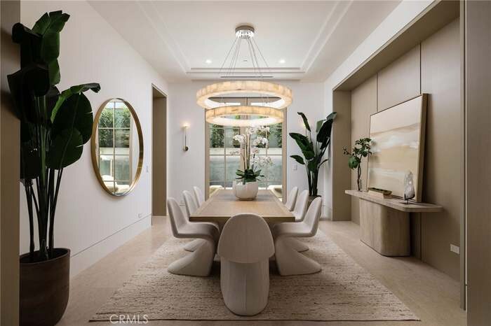 Dining room with a sculptural chandelier and curved chairs